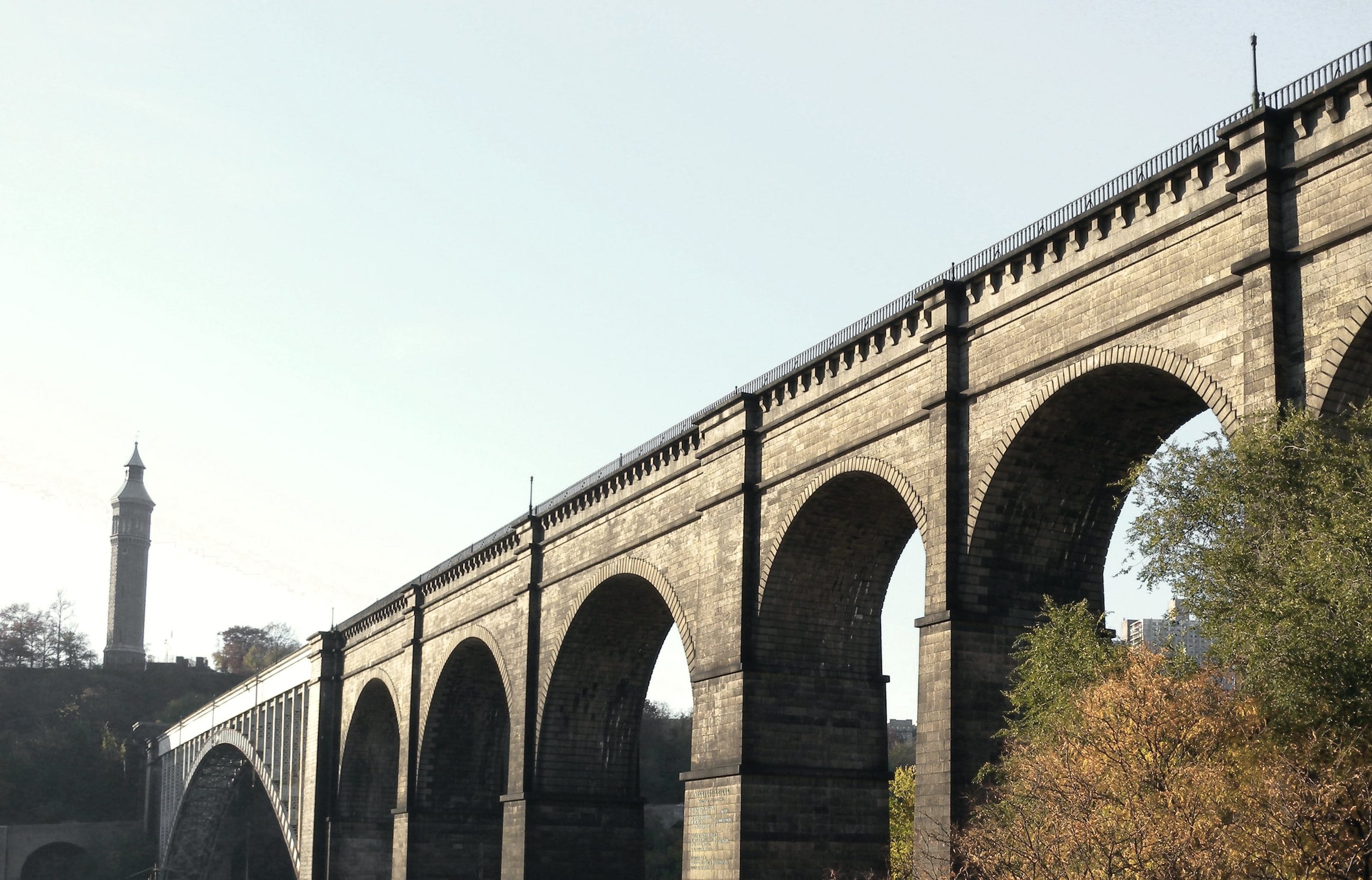 The stone arches of High Bridge, which carried the Old Croton Aqueduct across the Harlem River, in autumn light.