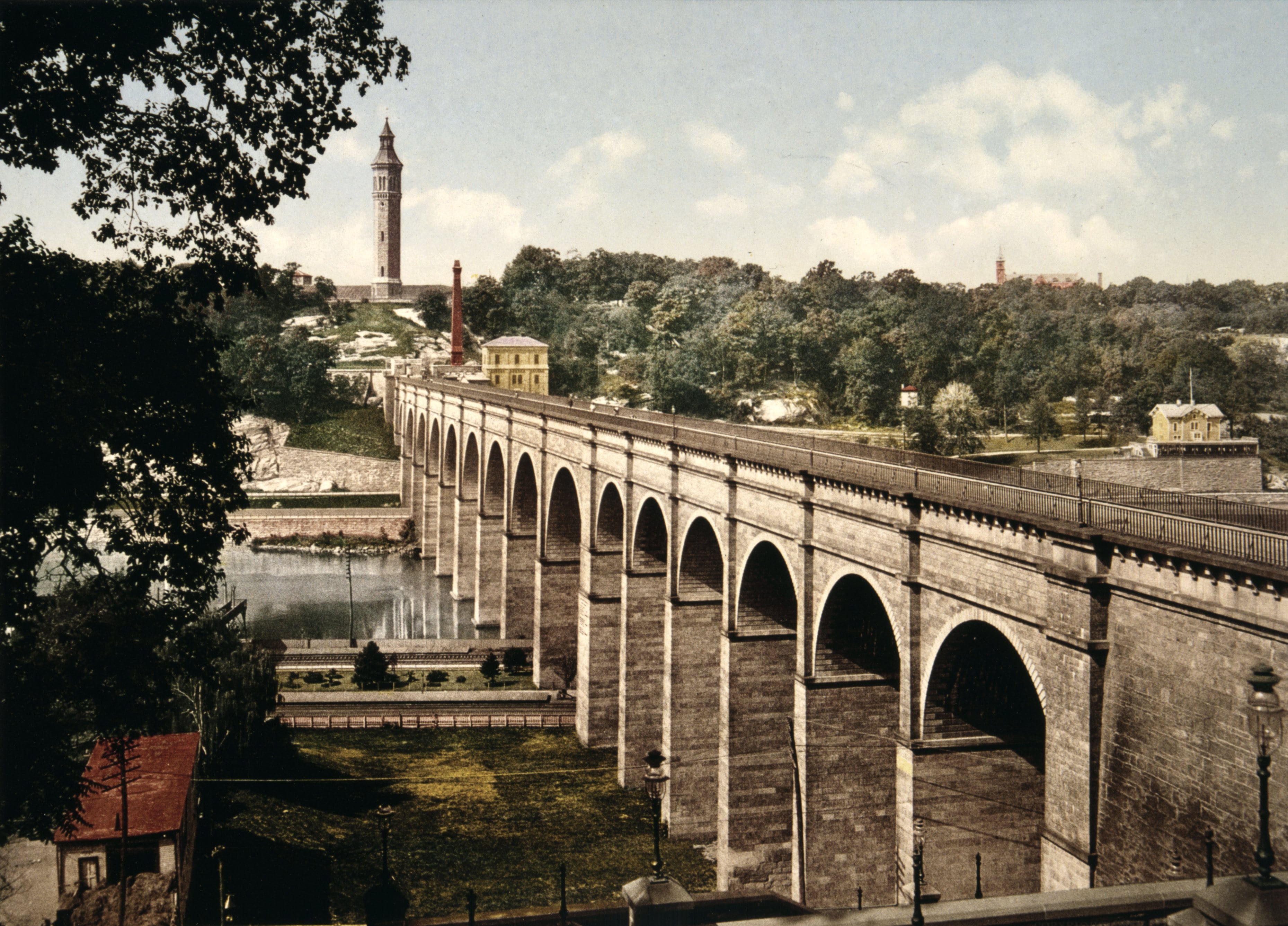 High Bridge around 1900: the stone arches of the Old Croton Aqueduct crossing the Harlem River, with the High Bridge Water Tower beyond.